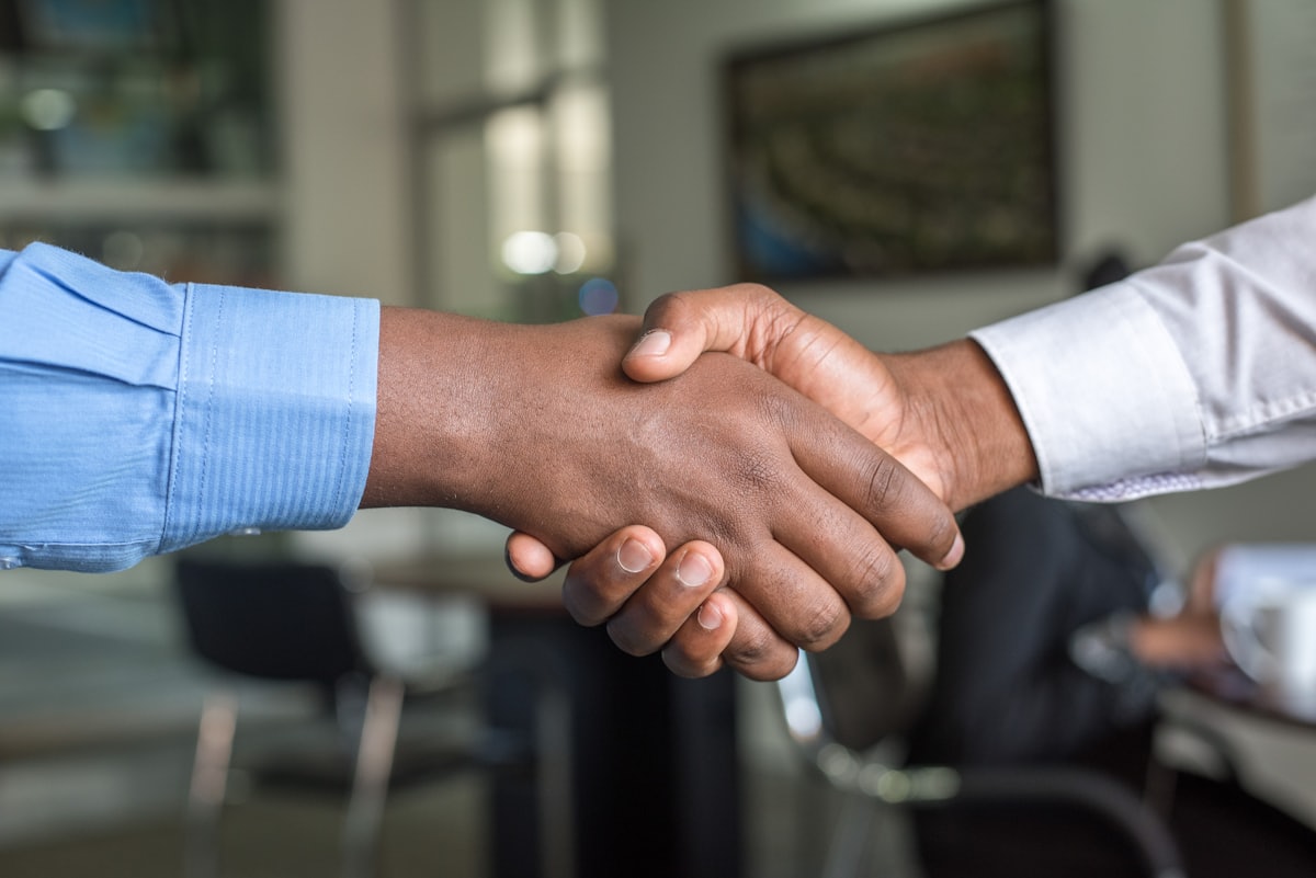 A professional handshake across a desk